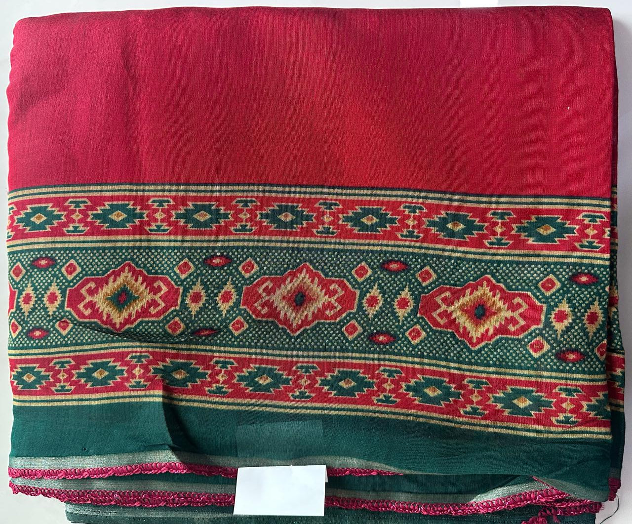 Red fabric with green and red pattern on a white background
