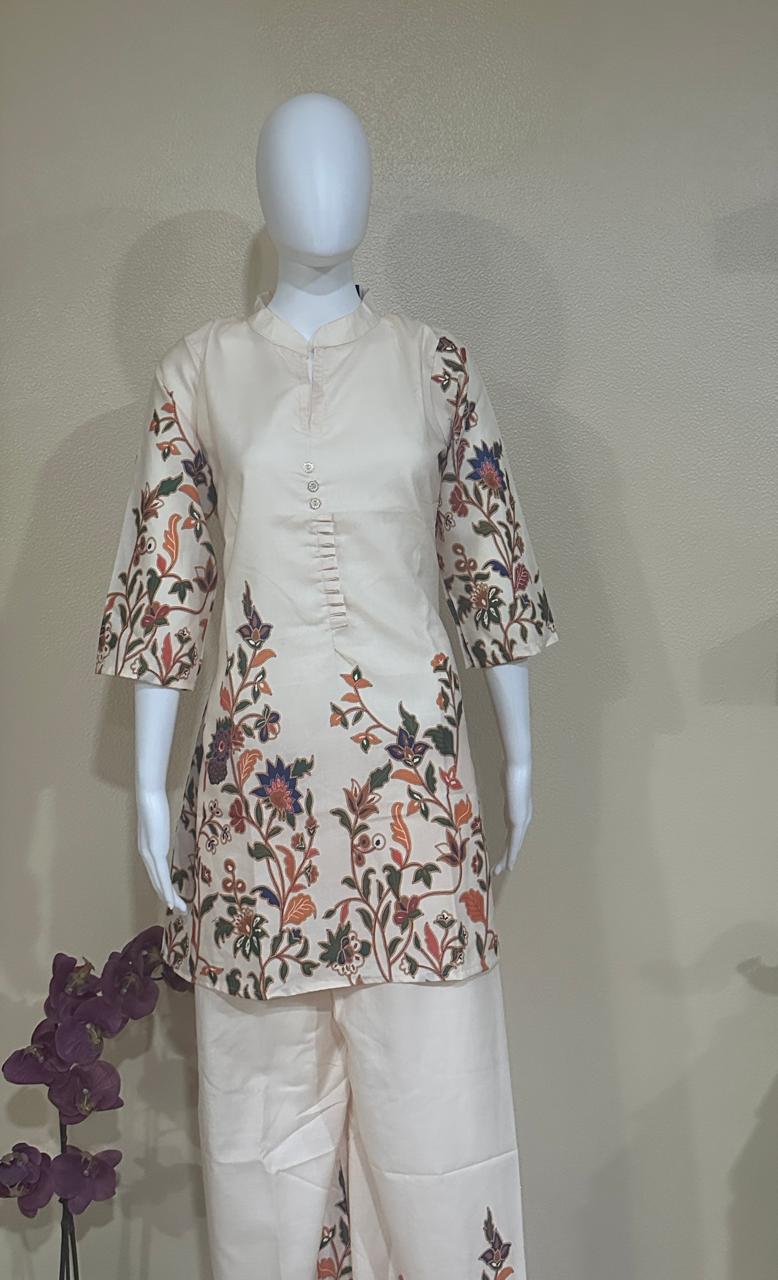 Mannequin wearing a traditional outfit with floral patterns on a plain background