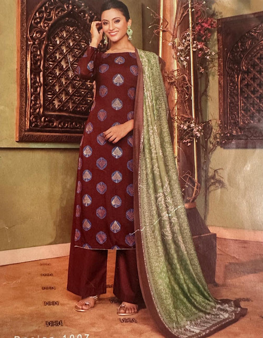 Woman wearing a maroon traditional outfit with a green dupatta in an ornate setting